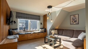 A modern living room with a built-in bench, a sofa, a coffee table, and a large window with a view.