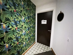 A hallway with a door labeled "No:166" and a wall mural of birds and foliage. - UrbanFlat 166 - Luxury Apartment in Center of Paris (París)
