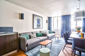 Ein modernes Wohnzimmer mit Sofa, Couchtisch und Essbereich.