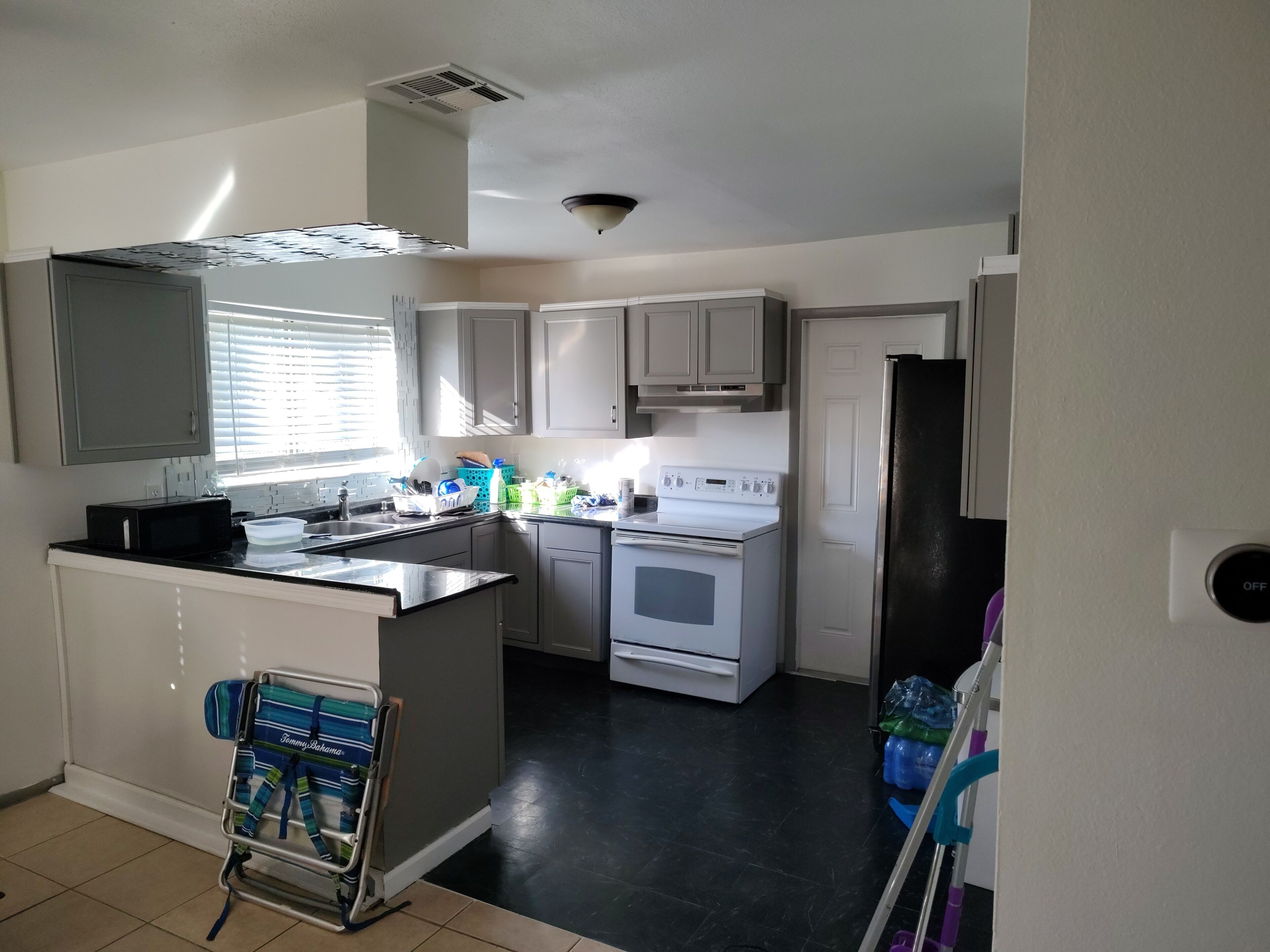 Cocina compacta con microondas, estufa y refrigerador.