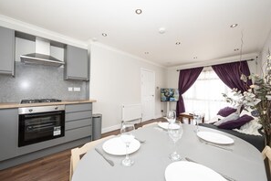 A modern kitchen with grey cabinets, a built-in oven, and a gas stove. - 4-Bedroom Family Home / Parking / Station - Pass the Keys (Belvedere)