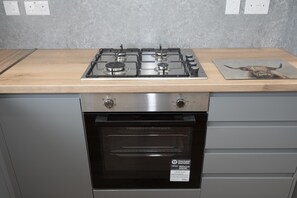 A kitchen with a gas stove, oven, and a wooden countertop. - 4-Bedroom Family Home / Parking / Station - Pass the Keys (Belvedere)