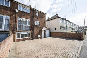 A residential street with houses, a paved driveway, and parked cars. - 4-Bedroom Family Home / Parking / Station - Pass the Keys (Belvedere)