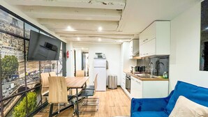 Un espacio habitable compacto con comedor, kitchenette y sofá.