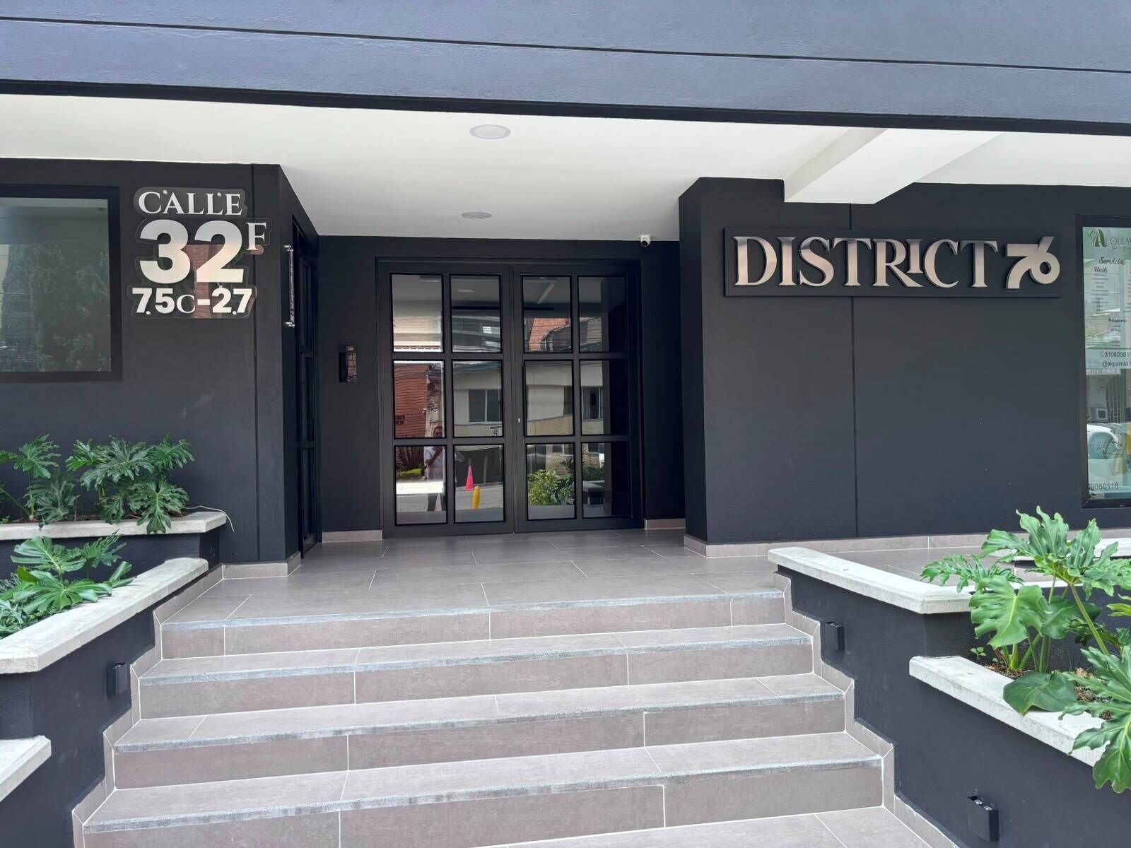 A building entrance with a sign reading 'C'ALLE 32 F 7.50-27' and 'DISTRICT 7'.