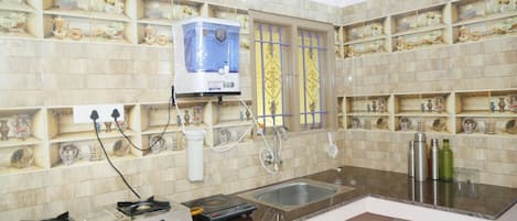 A kitchen with a gas stove, a coffee machine, and a sink.