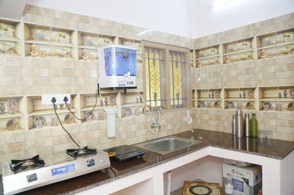 A kitchen with a gas stove, a coffee machine, and a sink.