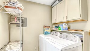 A laundry area with a washing machine, a drying rack, and storage cabinets. - Fantastic 3BR Mountainview Dog Friendly (South Fork)