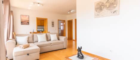 Una sala de estar con un sofá, una mesita y un cuadro en la pared.
