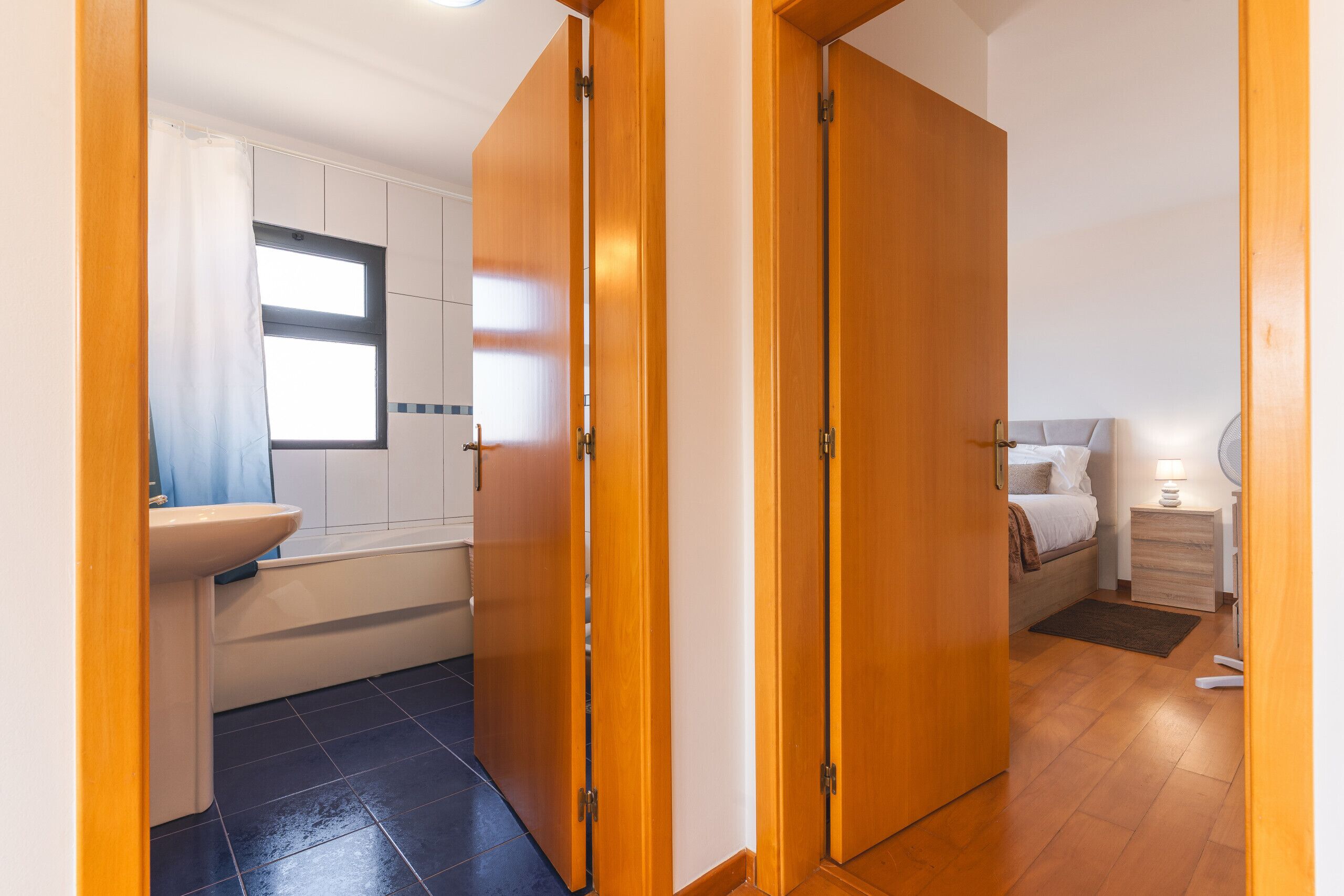 A bathroom with a toilet, sink, and window.