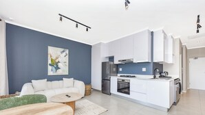 Een moderne woonkamer met een bank, een salontafel en een schilderij aan de muur.
