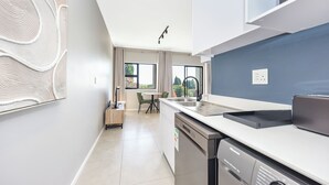 Een moderne keuken met een vaatwasser, een spoelbak en een eethoek met een tafel en stoelen.