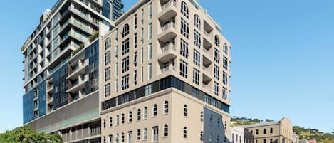 Un edificio de varios pisos con una mezcla de estilos arquitectónicos modernos y clásicos, con balcones y ventanas amplias.