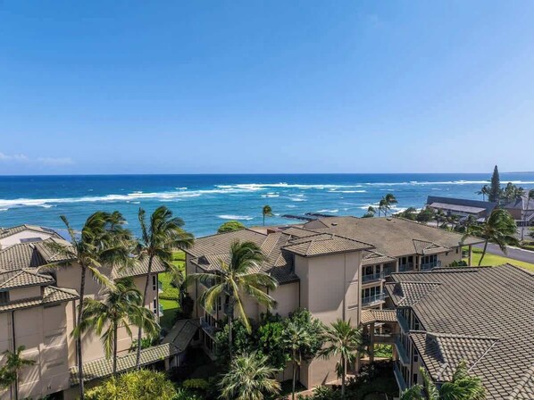 A coastal residential area with multiple buildings, some with balconies, and a view of the ocean. - New Listing- Waipouli Ocean front, Pool, AC, GYM, Waterslide! (Kapaa)