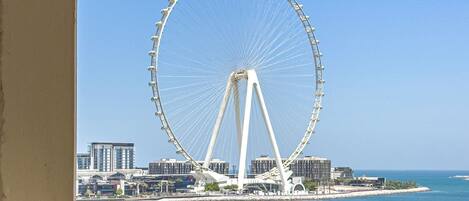 Une grande roue offrant une vue dégagée sur les bâtiments environnants et la mer.