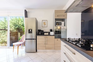 Una cocina moderna con refrigerador, microondas y estufa a gas.