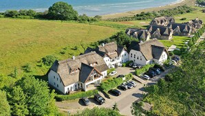 A coastal property with multiple houses, a parking area, and a view of the sea. - "Dünenrose" Beach Studio in Lobbe, with a balcony—4 minutes from the sandy beach (Mönchgut)