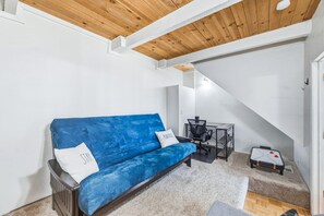 A room with a blue sofa, a small table, and a chair. - Quiet Tahoe Retreat • Near Heavenly & Hiking (Stateline)