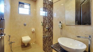 A modern bathroom with a toilet, a sink, and a shower. - Hotel Iceberg Mahabaleshwar Venna Lake  (Mahabaleshwar)
