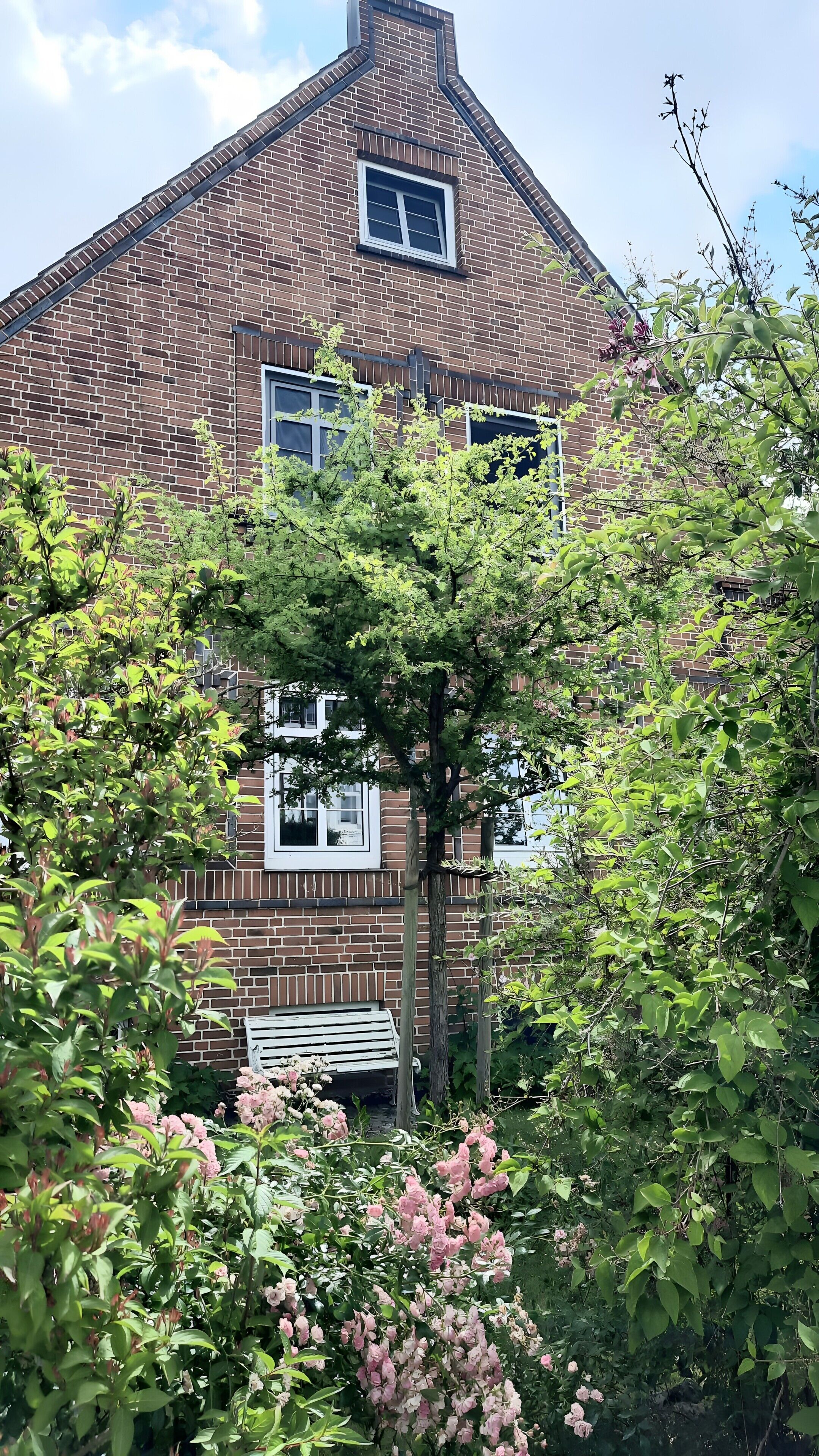 Ein Haus aus Ziegelsteinen mit einem Satteldach und einem Fenster.