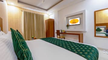 A hotel room with a bed, a desk, a chair, a television, and a mirror.