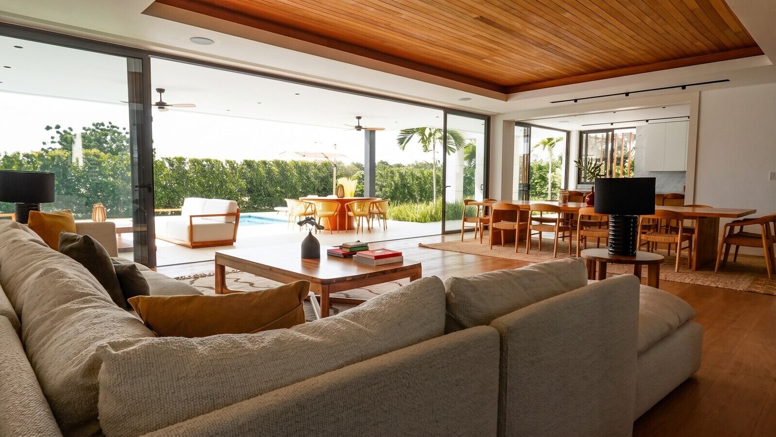 Una sala moderna con un sofá grande, una mesa de centro y un comedor con sillas y una mesa.