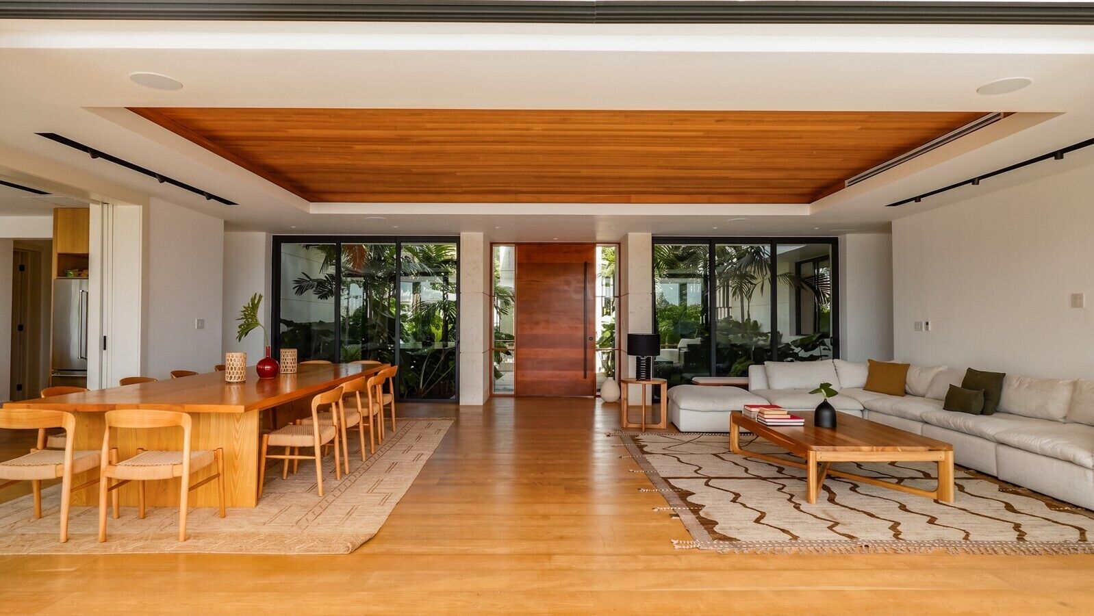 A spacious living area with a wooden dining table and chairs, a sofa, and a coffee table.