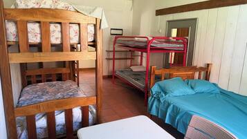 Una habitación con literas, una cama individual y un escritorio.