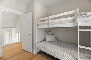 A room with a bunk bed, a door, and a staircase. - Serendipity: New Build | Saltwater Pool | Hot Tub (Corolla)