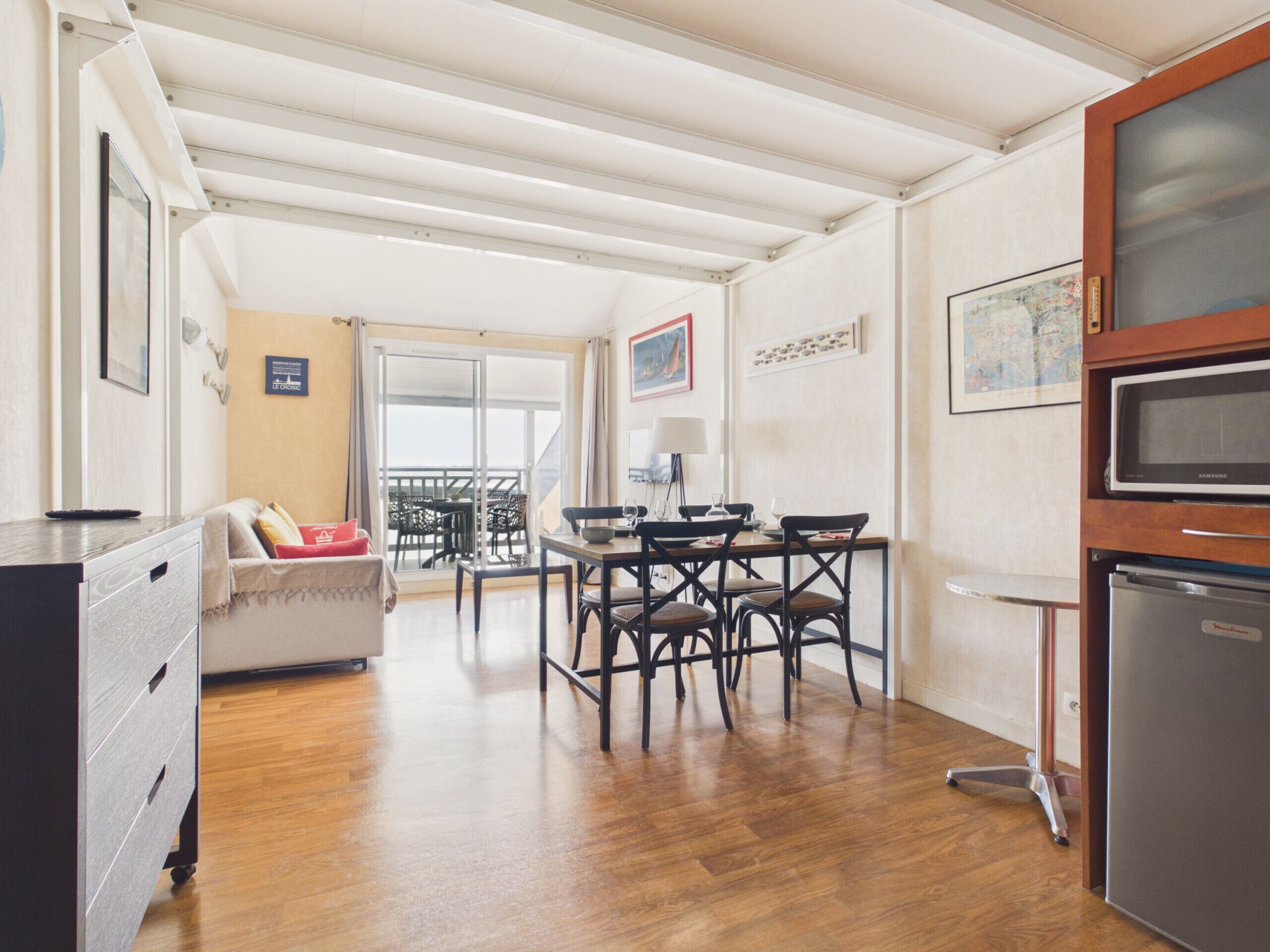 A compact living space with a kitchenette, dining area, and a balcony.