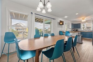 A modern kitchen with a dining area, large windows, and a view of the outside. - Canalfront | Private Boat Dock | Hot Tub | Pool Access (Nags Head)