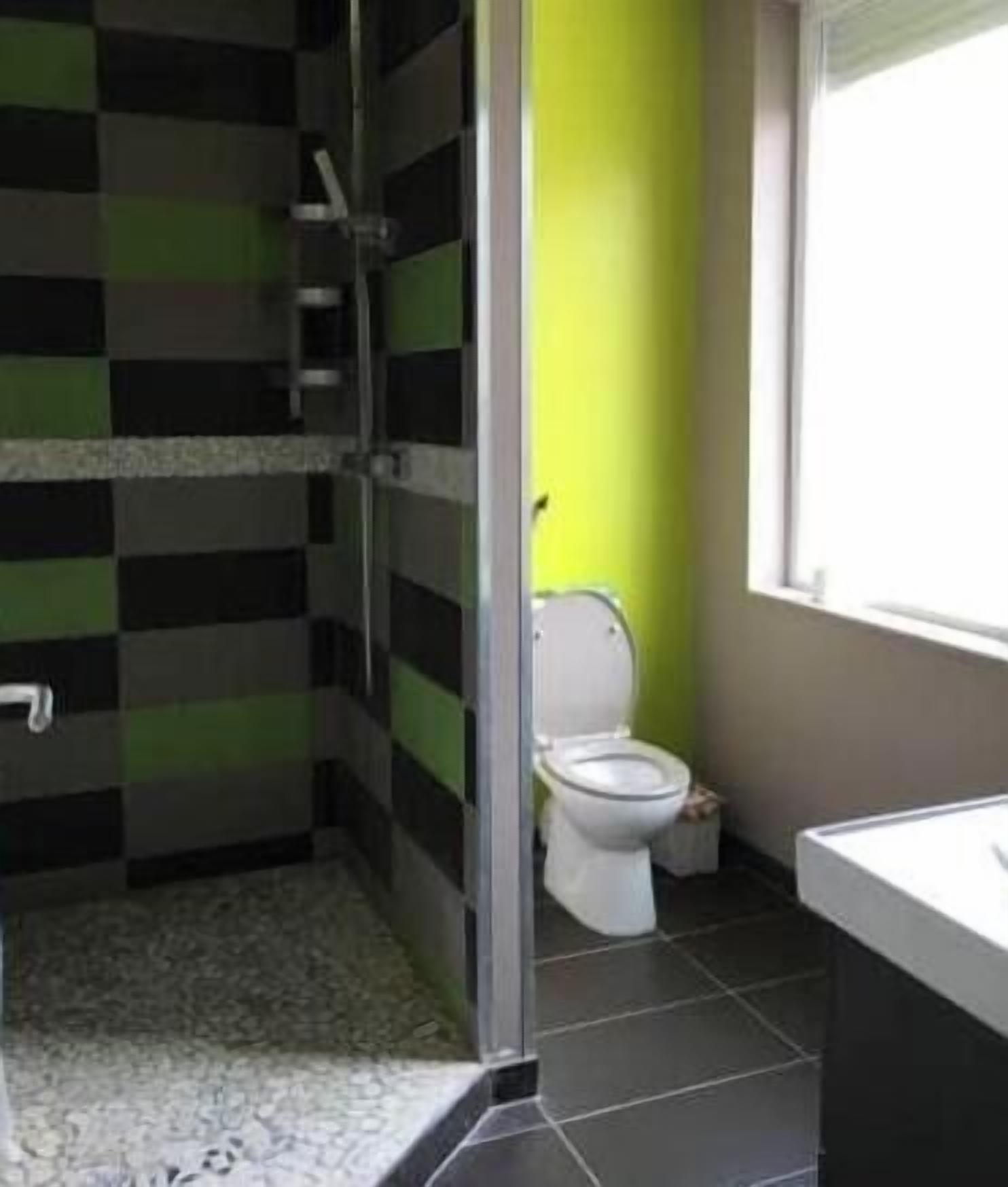 A bathroom with a shower, toilet, and sink.