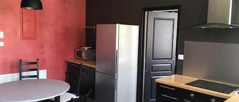 Una cocina funcional con refrigerador, microondas y estufa.
