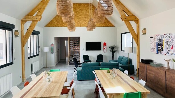 A spacious loft with a high ceiling, wooden beams, a dining area with a long table, and a living area with a sofa and chairs. - La Menuiserie in the Baie de Somme: 15 people (Fort-Mahon-Plage)