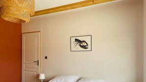 A bedroom with a bed, two bedside tables with lamps, a door, and a wall-mounted picture. - La Menuiserie in the Baie de Somme: 15 people (Fort-Mahon-Plage)