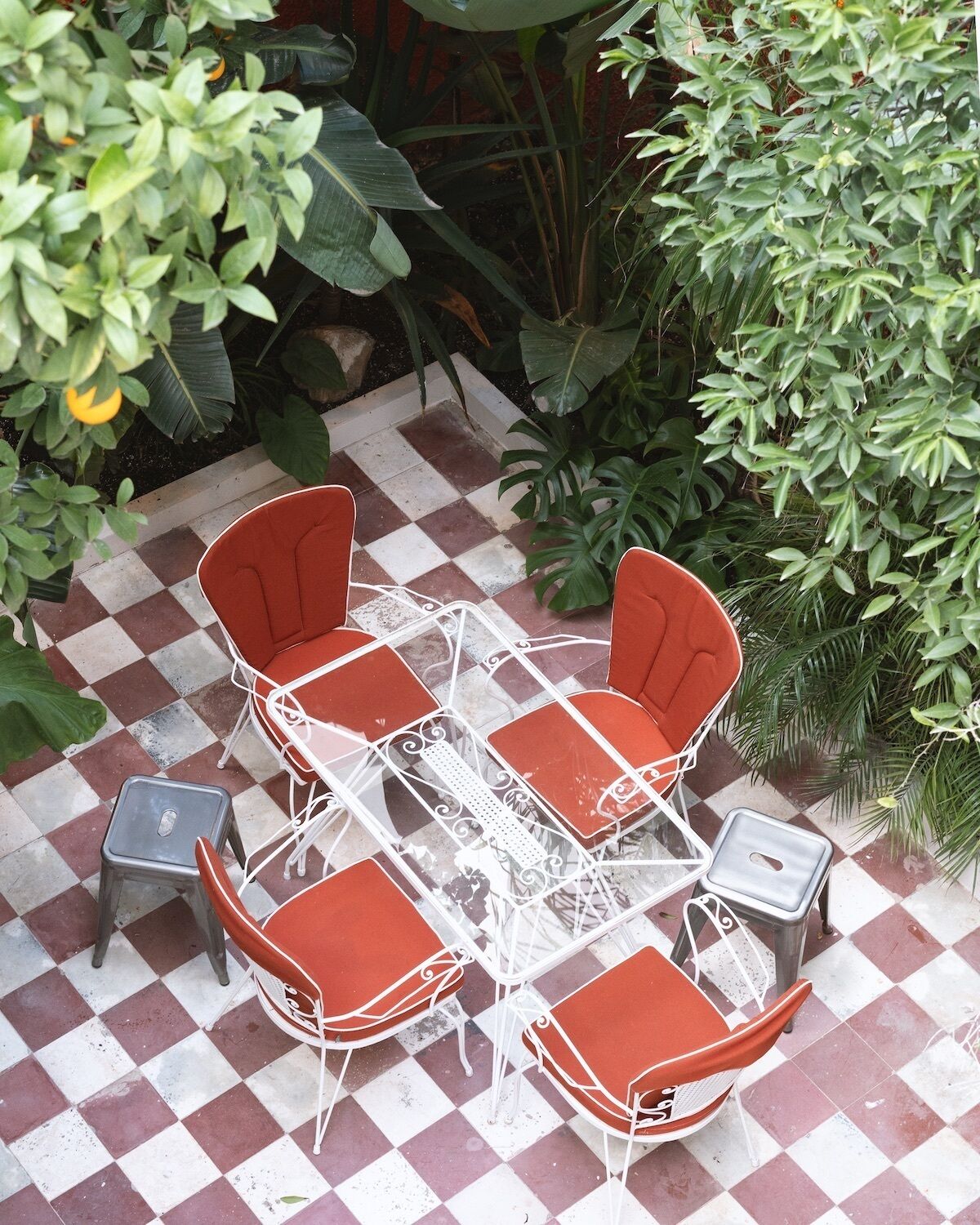 Un patio al aire libre con piso a cuadros, una mesa y cuatro sillas.