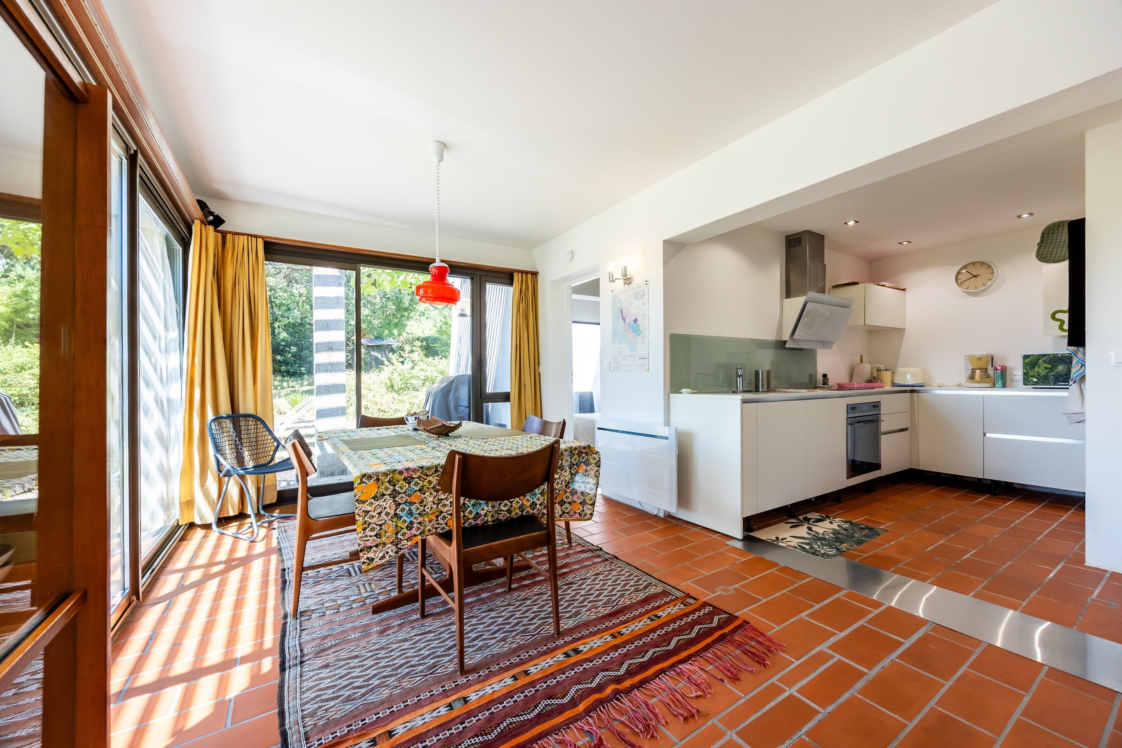 A compact kitchen with white cabinets, a stove, and a sink.