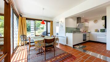 A compact kitchen with white cabinets, a stove, and a sink.