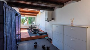 A gym with exercise equipment, a massage table, and a cabinet. - Villa Fiola 8, Emma Villas (Ancona)