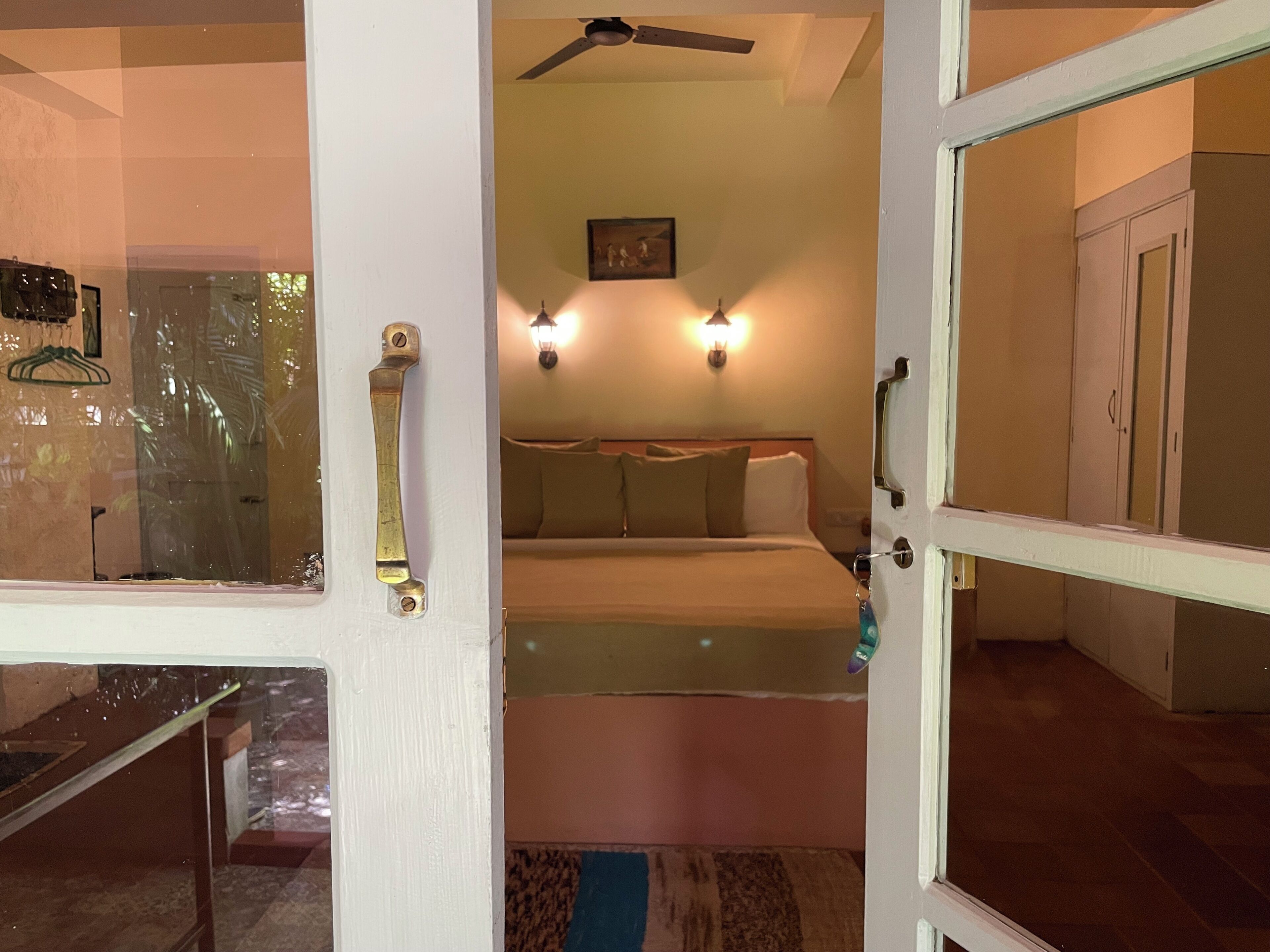 Ein Schlafzimmer mit einem Bett, Nachttischlampen, einem Deckenventilator und einem Bild an der Wand.