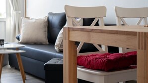 Un salon moderne avec un canapé, une table et deux fauteuils.