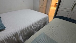A room with two beds, one with a blue pillow and the other with a white pillow. - Decorated corner near the beach in Jardim Camburi (Vitória)
