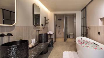 A modern bathroom with a large bathtub, a separate shower area, and a vanity with a large sink.