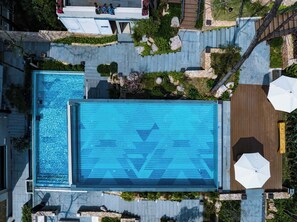 Una piscina al aire libre, sillones reclinables de piscina