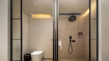 A modern bathroom with a glass door, a toilet, a shower, and a towel rack.