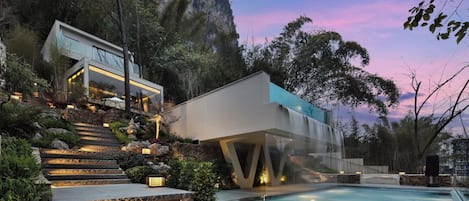 Edifici modern amb piscina, envoltat d'escales i vegetació.