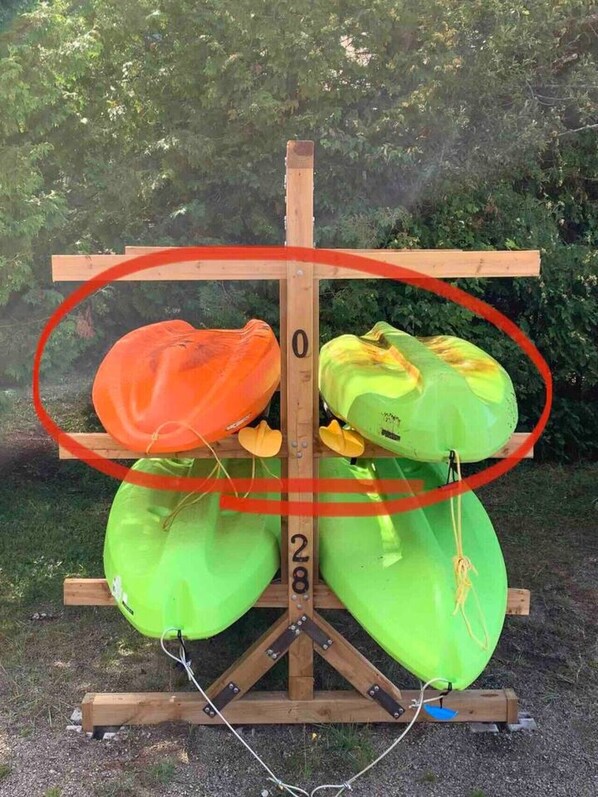 A wooden stand with two green objects and one orange object, possibly for testing or display.