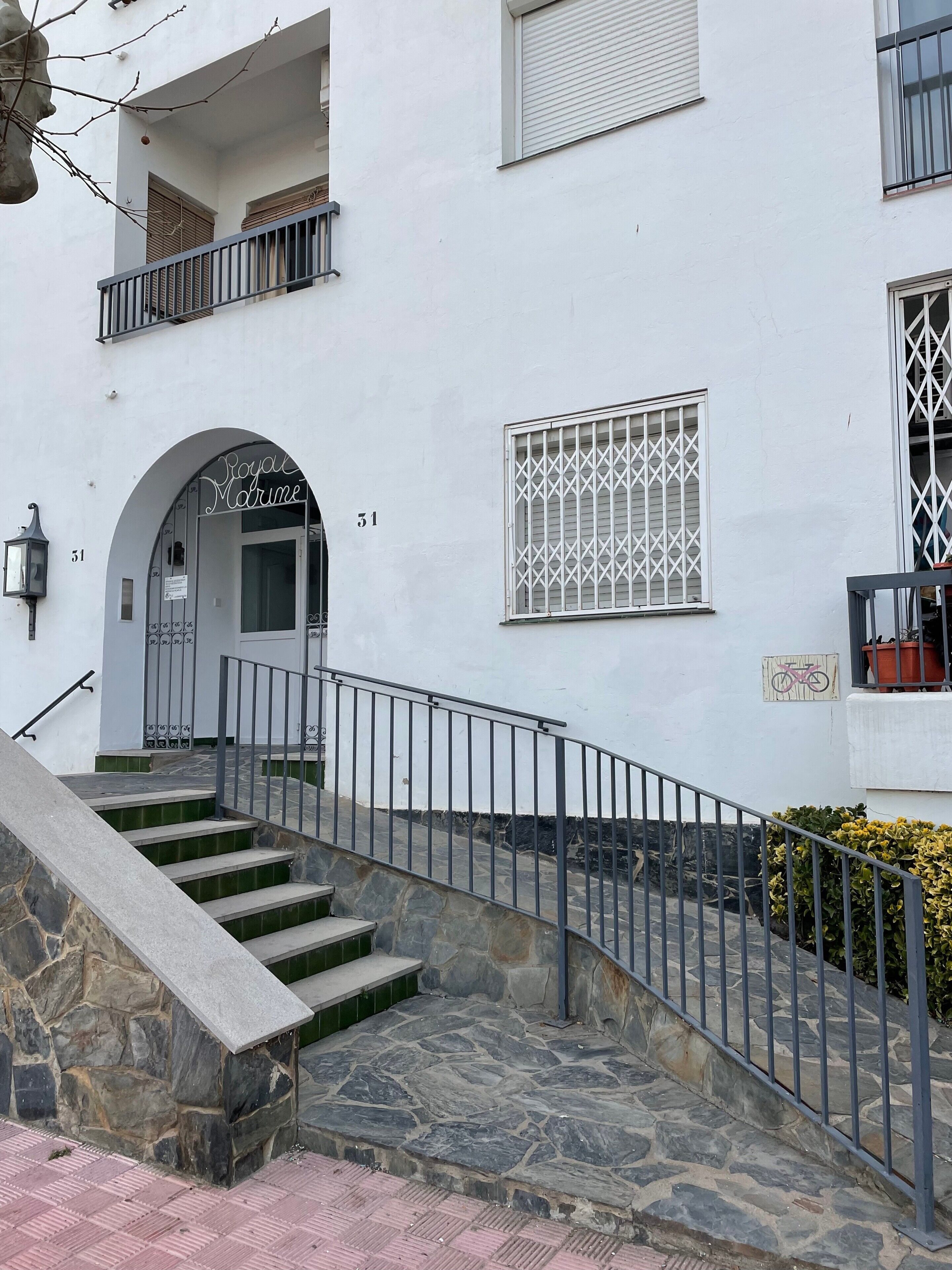A building with a stone staircase leading to a door marked 'Royal Marine.'