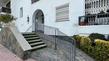 A multi-story building with a stone staircase leading to an entrance.