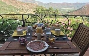 A table set outdoors with a view of the countryside.